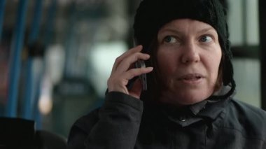 Güzel yetişkin kadın üstünde hareket eden telefon içinde halk otobüsü soğuk kış öğleden sonra el ağır çekim söz.