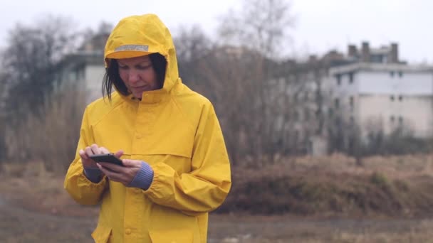 Frau Gelbem Regenmantel Die Regnerischen Tagen Freien Mobiltelefon Sms Sendet — Stockvideo