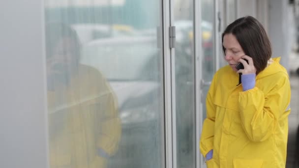 Sad Woman Yellow Raincoat Talking Mobile Phone Out Street While — Stock Video