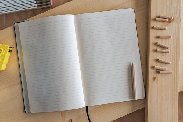 Cuaderno abierto con páginas en blanco en taller de carpintería — Foto de Stock