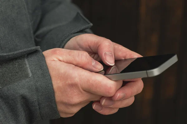 Casual female is texting message on mobile phone on street — Stock Photo, Image