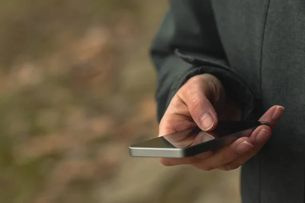 Příležitostné žena je SMS zpráv na mobilní telefon na ulici — Stock fotografie