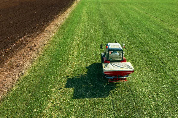 Tractor agrícola fertilizante campo de cultivo de trigo con NPK —  Fotos de Stock