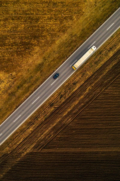 Coches y camiones en la carretera a través del campo, vista aérea —  Fotos de Stock