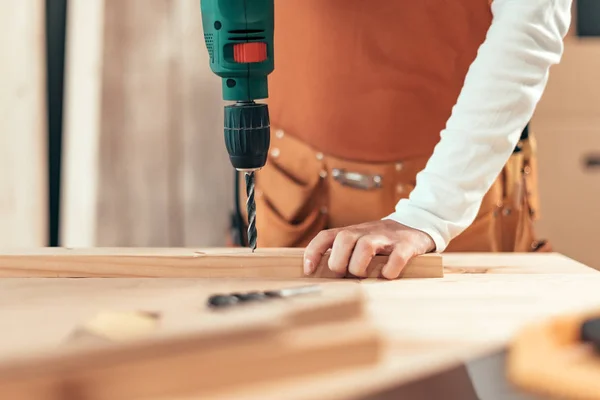 Female carpenter using electric drill — Stock Photo, Image