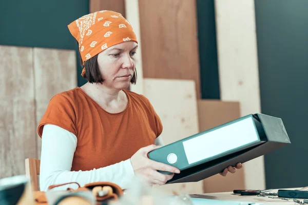 Self employed female carpenter with document ring binder — Stock Photo, Image