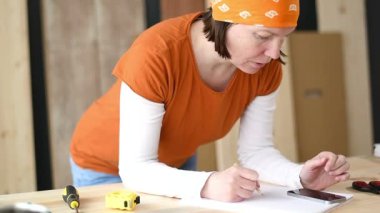 Kadın marangoz marangozluk doğrama Atölyesi, ağır çekim el görüntüleri proje hesaplama yapıyor