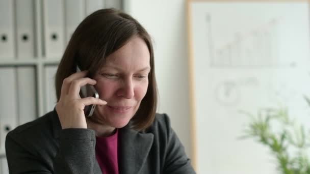 Neşeli Işkadını Ofis Ağır Çekim Görüntüleri Masasında Otururken Cep Telefonu — Stok video