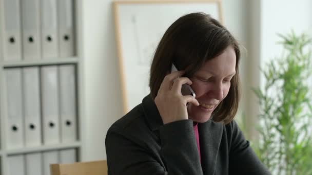 Mulher Negócios Alegre Falando Telefone Celular Enquanto Sentado Mesa Escritório — Vídeo de Stock