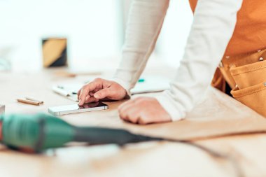 Kadın marangoz metin iletileri için cep telefonu kullanıyor