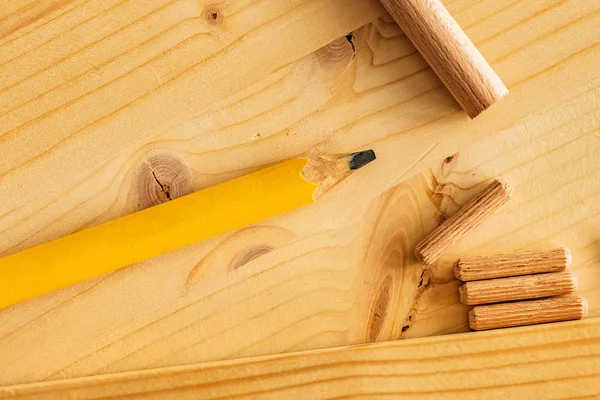 Carpenter'ın kalem ve çalışma masası üzerinde ahşap dübeller — Stok fotoğraf