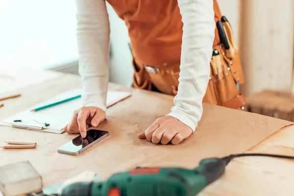 Kadın marangoz Smartphone kullanarak — Stok fotoğraf