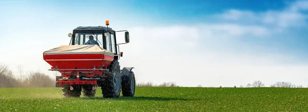 Agricultural tractor fertilizing wheat crop field with NPK — Stock Photo, Image