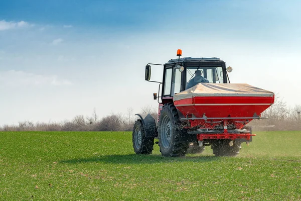 Trator agrícola que fertiliza campo de cultivo de trigo com NPK — Fotografia de Stock