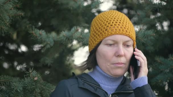 Serious Adult Woman Talking Mobile Phone Park Wearing Yellow Cap — Stock Video