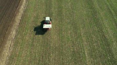 Tarım traktörü buğday kırpma alanıyla Npk gübrelerin, dron pov havadan görünümden gübreleme