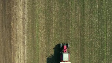 Tarım traktörü buğday kırpma alanıyla Npk gübrelerin, dron pov havadan görünümden gübreleme