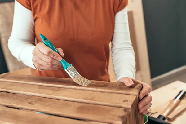 Kadın marangoz ahşap sandık fırça ile vernik — Stok fotoğraf