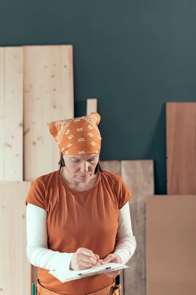 Kendi kendine çalışan kadın marangoz Project notları yazma — Stok fotoğraf
