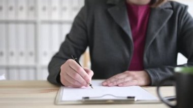 İşkadını masada otururken iş ofisinde Pano Notepad kağıt üzerinde notlar yazma, Dolly Slider shot