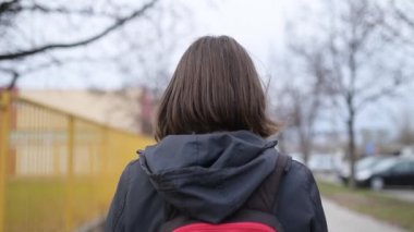 Casual yetişkin Kafkas kadın şehrin bulutlu bahar öğleden sonra ağır çekim el görüntüleri sokak aşağı yürüyüş görünümünü arka