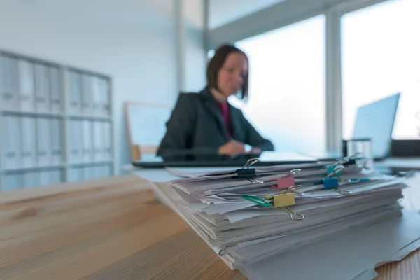 Empresária ocupada a tratar da papelada no escritório — Fotografia de Stock