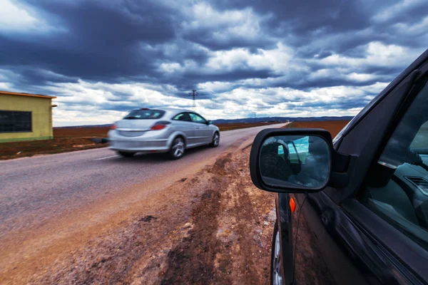 Broken car stopped by the road on stormy day