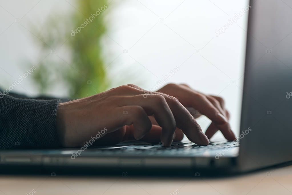 Businesswoman typing laptop keyboard, close up of hands