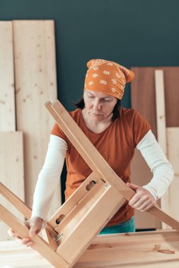 Kadın marangoz atölyesinde ahşap sandalye koltuk tamiri