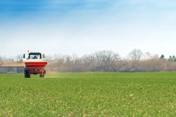 Сельскохозяйственные тракторы, удобряющие посевы пшеницы с использованием NPK — стоковое фото