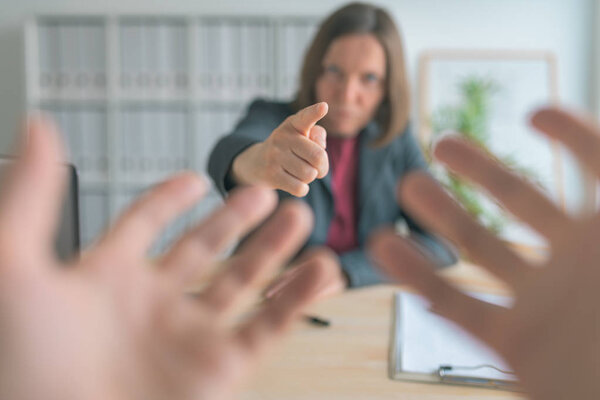 Boss threatening employee with finger in business office