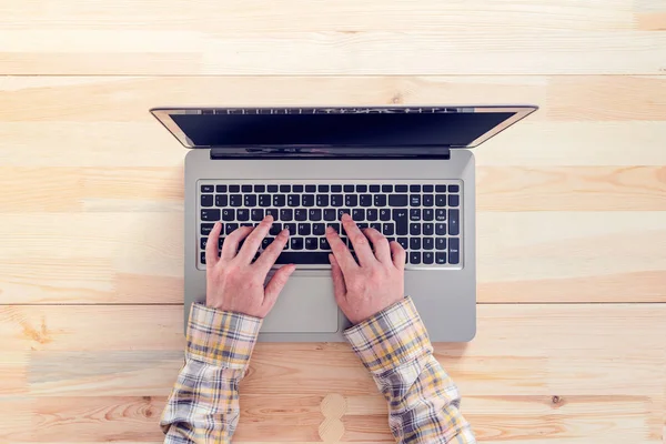 ラップトップ コンピューターのキーボードで入力する女性の手の上から見る — ストック写真