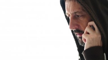 Cep telefonu, beyaz arka plan üzerinde izole konuşmak hoodie ile gergin adam