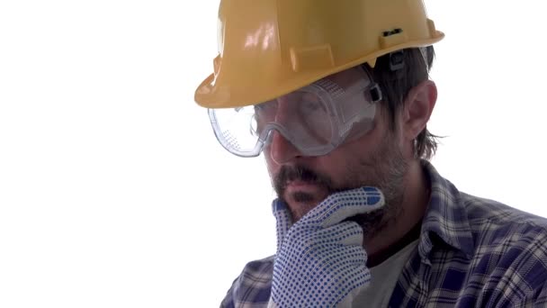 严重周到的建筑工程师的肖像与安全帽和防护镜隔离在白色背景 — 图库视频影像