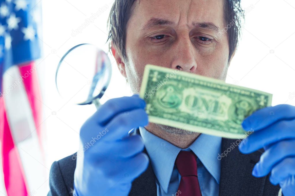 American secret service agent analyzing suspicious counterfeit d