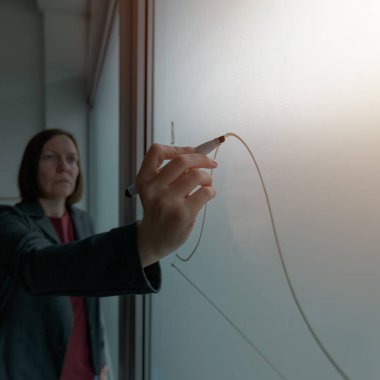 İş kadını ofiste beyaz tahta üzerinde grafik çizim