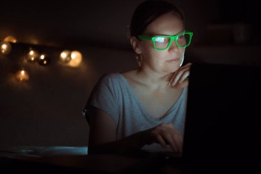 Gece laptop üzerinde çalışan kadın düşük anahtar portre