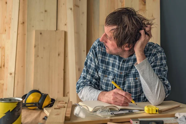 Плотник мыслит в интерьере мастерской по деревообработке — стоковое фото