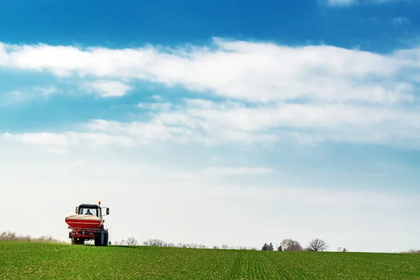 Agricultural tractor fertilizing wheat crop field with NPK — Stock Photo, Image