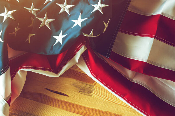 USA flag crumpled on wooden background