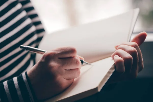 Mujer escribiendo diario junto a la ventana — Foto de Stock