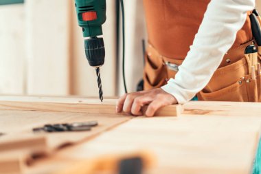 Kadın marangoz elektrikli matkap kullanarak