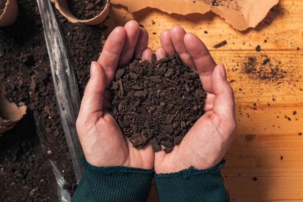 Jardinero sosteniendo tierra en las manos ahuecadas, vista superior — Foto de Stock