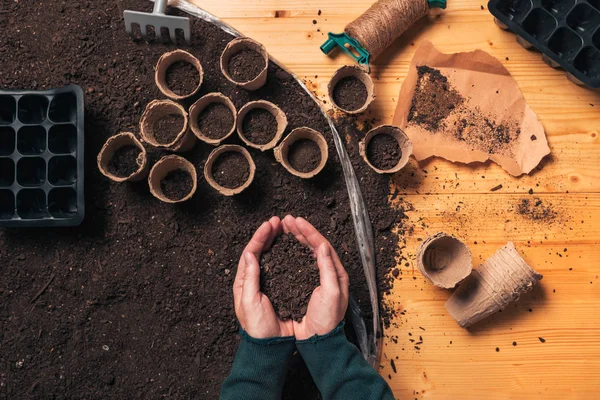 Bahçıvan bardaklı ellerde toprak tutan, üst görünümü — Stok fotoğraf