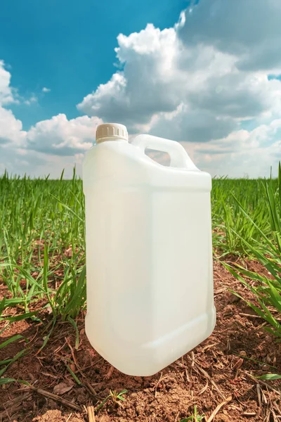 Contenitore di brocca di pesticidi vuoti finto nel campo di erba di grano — Foto Stock