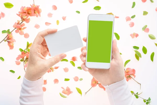 Springtime visitkort och smartphone i kvinnliga händer mock up — Stockfoto