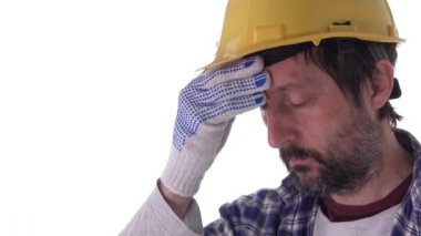 Endişeli inşaat işçisi beyaz arka planda izole edilmiş, sarı koruyucu kask takıyor, sorunlar ve belirsizliklerle boğuşuyor.