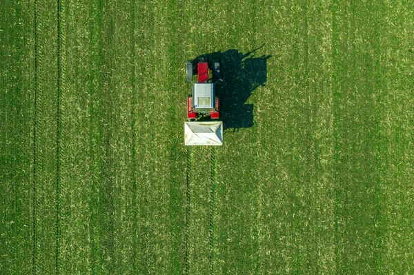 Trator agrícola que fertiliza campo de cultivo de trigo com NPK — Fotografia de Stock