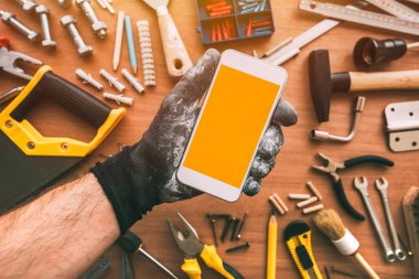 Handyman akıllı telefon uygulaması, elinde cep telefonu tutan tamirci