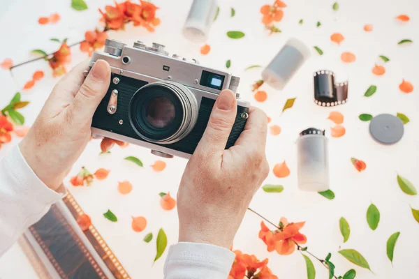 Donna con fotocamera vintage sopra decorazione floreale primaverile — Foto Stock